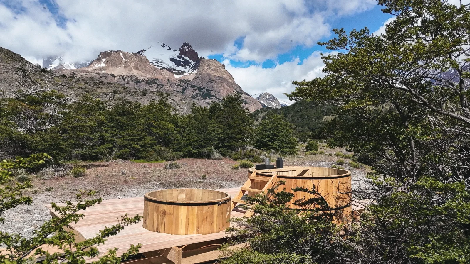The wooden hot tub and cold plunge with the mountains behind